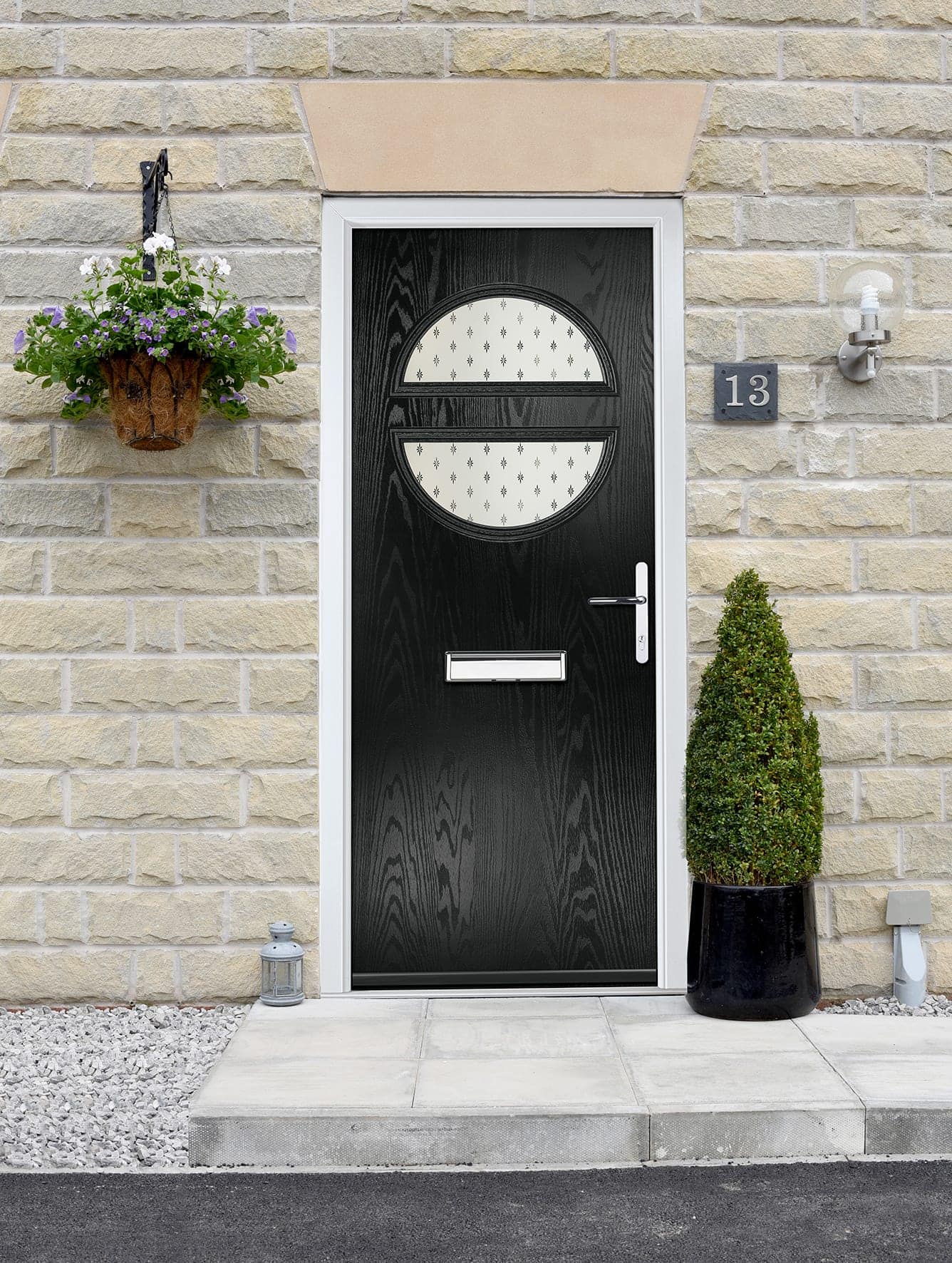 Black composite front door with an oval glazed panel